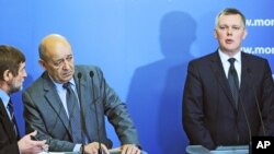 Defense Minister of France, Jean-Yves Le Drian, second left, listens to a translator during a press conference with his Polish counterpart Tomasz Siemoniak, right, in Warsaw, Poland, Nov. 25, 2014.
