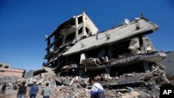 터키 정부의 통행금지령이 해제된 다음날인 2일 지즈레 지역 주민들이 붕괴된 건물 주변을 걷고 있다.
