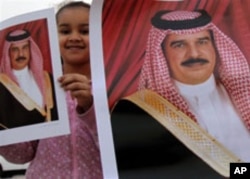 A girl holds up a picture of Bahrain's King Hamad bin Isa Al Khalifa in Muharraq, Bahrain, February 16, 2011, during a gathering to counter three days of anti-government demonstrations