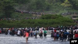 Salvadorean migrants heading in a caravan to the US, cross the Suchiate River to Mexico, as seen from Ciudad Tecun Uman, Guatemala, Nov. 2, 2018.