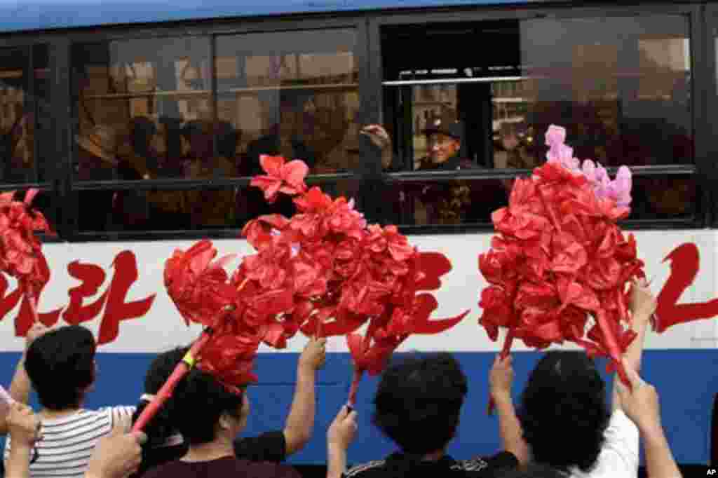 북한 전승절 경축행사를 위해 평양을 방문한 전쟁 노병들에게 환영 인파가 꽃을 흔들고 있다.