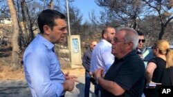Greece's Prime Minister Alexis Tsipras (L) visits the burnt area of Mati, east of Athens, July 30, 2018. 