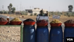 Peshmerga soldiers pull out after purchasing olives formerly only available to IS militants, because local people could not afford the luxury under their rule on Nov. 23, 2016. (H.Murdock/VOA)