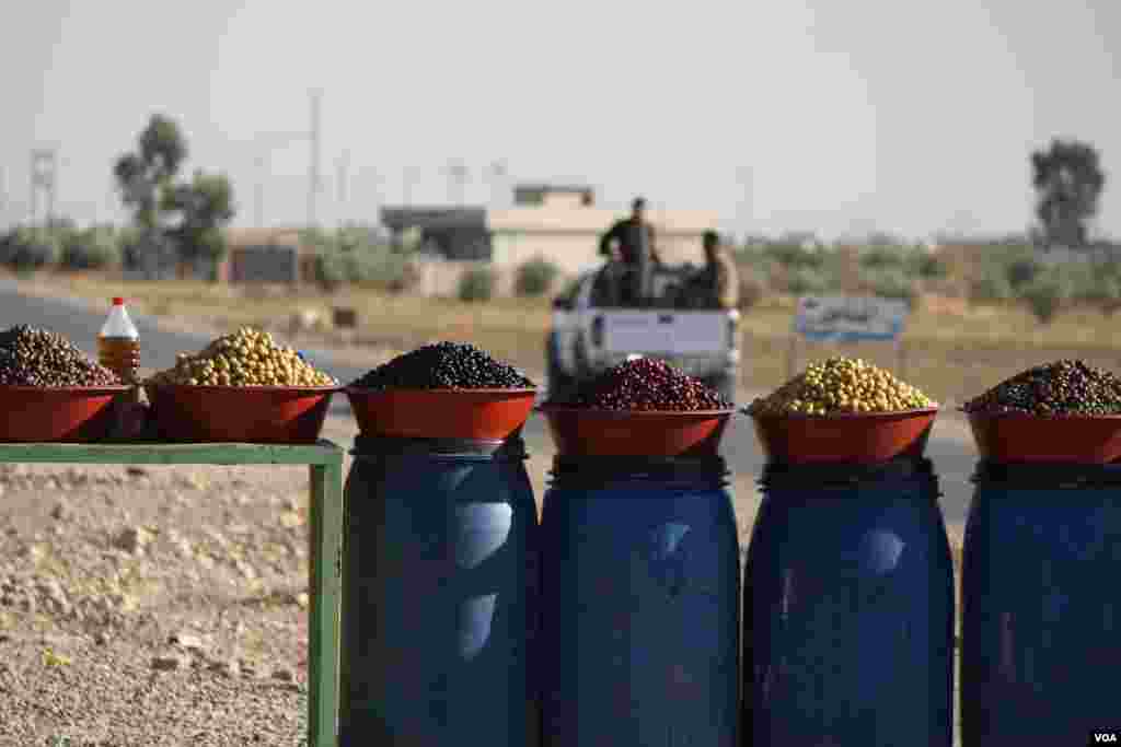 Peshmerga soldiers pull out after purchasing olives formerly only available to IS militants, because local people could not afford the luxury under their rule on Nov. 23, 2016. (H.Murdock/VOA)