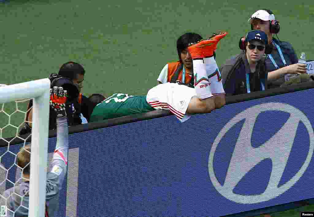 Mexico's Paul Aguilar falls into the photographers pit during the 2014 World Cup round of 16 game between Mexico and the Netherlands at Castelao arena in Fortaleza, Brazil.