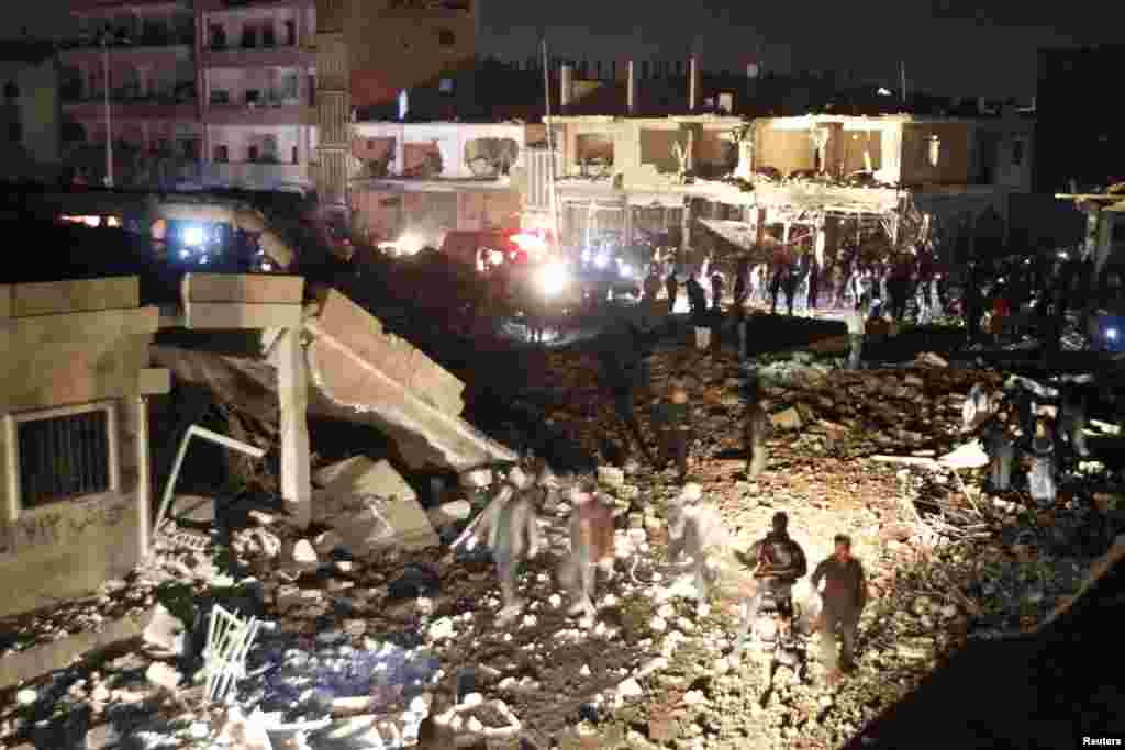 Residents gather at a site hit by what activists say was a Scud missile from forces loyal to Syria's President Bashar al-Assad in Raqqa, Nov. 28, 2013.