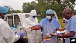 အီဘိုလာ ရောဂါသည်တွေကို ကာကွယ်စောင့်ရှောက်ပေးနေတဲ့ ဆေးဝန်ထမ်းများ။ 