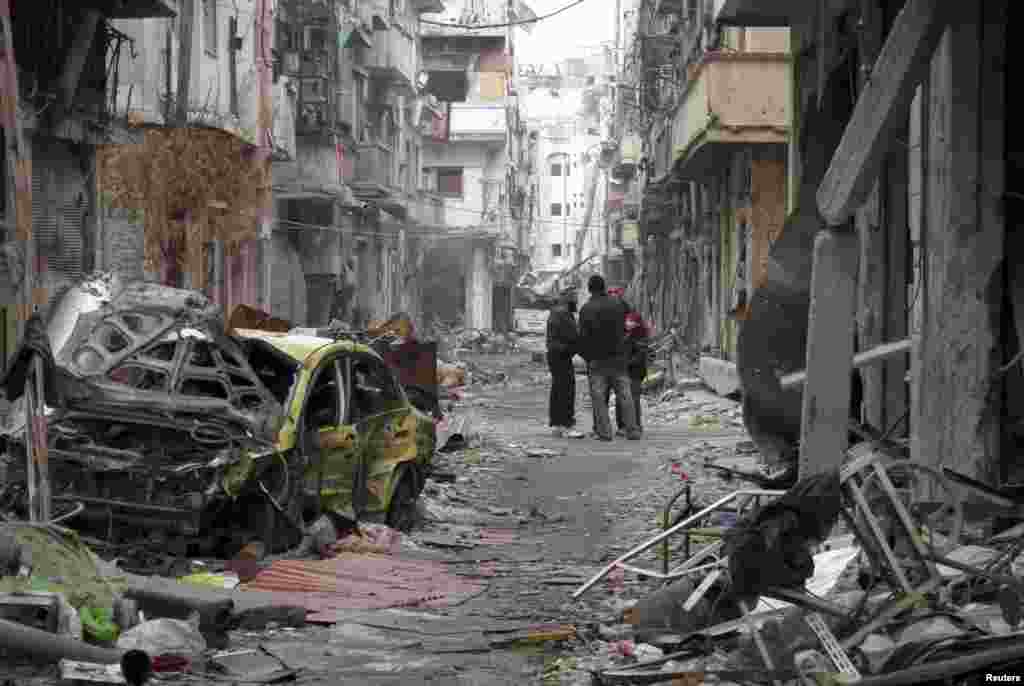 غیرنظامیان در میان ویرانه های بخش تحت محاصره حمص - ۲۷ ژانویه ۲۰۱۴