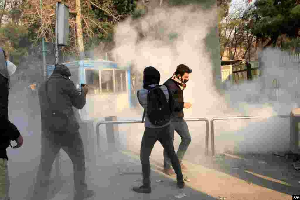 Iranian students run for cover from tear gas at the University of Tehran during a demonstration driven by anger over economic problems, in the capital Tehran, Iran, Dec. 30, 2017. 