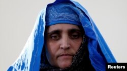 FILE - Sharbat Gula, the green-eyed 'Afghan Girl' whose 1985 photo in National Geographic became a symbol of her country's wars, arrives to meet with Afghanistan's President Ashraf Ghani in Kabul, Afghanistan, Nov. 9, 2016. 