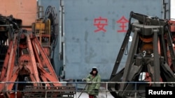 지난 2010년 북-중 접경 도시인 단둥 항구에서 중국인 노동자가 북한에서 들여온 수입품을 선적하기 위해 대기 중이다. (자료사진)