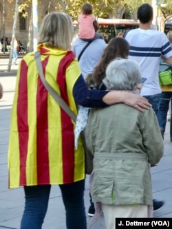 A guiding hand: grand-daughter and grandmother make their way to join a pro-independence rally Sunday in Barcelona.