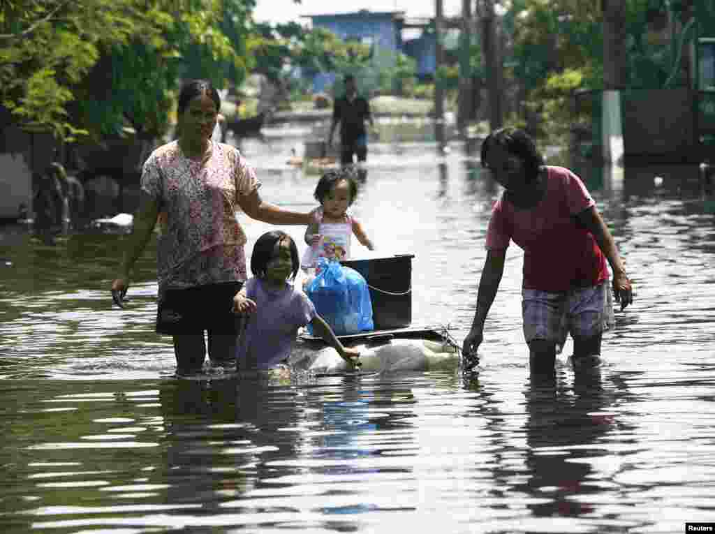 Residents use an improvised raft, made of styrofoam, to cross floodwaters at Dampalit town in Malabon city, north of Manila, August 11, 2012.