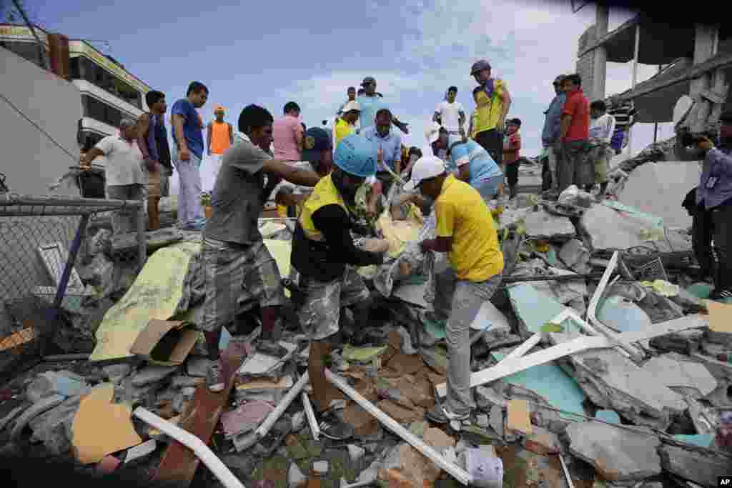 Volunteers rescue a body from a destroyed house after a massive earthquake in Pedernales, April 17, 2016.