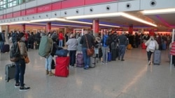 Passengers queue at London Heathrow Airport's T3 as the US reopens its borders to UK visitors in a significant boost to the travel sector, in London, Monday, Nov. 8, 2021. (Steve Parsons/PA via AP)