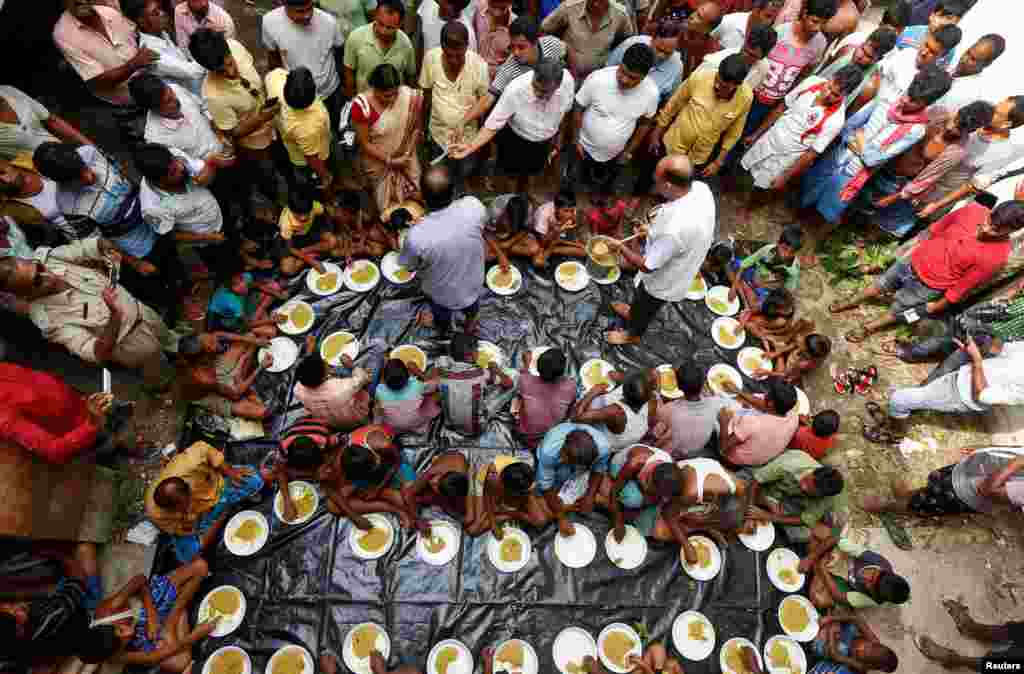 People eat inside a flood relief camp on an island in Howrah district, West Bengal, India.