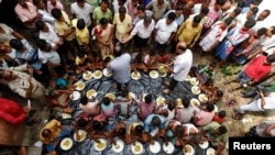 People eat inside a flood relief camp on an island in Howrah district, West Bengal, India, July 28, 2017. 