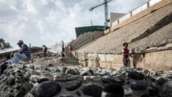 Des jeunes sénégalais se dirigent vers la célèbre plage des Mammelles à travers des chantiers à Dakar le 27 juin 2020.