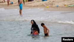 Seorang perempuan Muslim memakai burkini di pantai di Marseille, Perancis (17/8). 