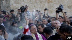 Latin Patriarch of Jerusalem Fouad Twal, center, performs a blessing before entering the Church of Nativity, traditionally believed by Christians to be the birthplace of Jesus Christ, before beginning Christmas celebrations in the West Bank town of Bethle