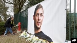 Ramos de flores y otros tributos desplegados cerca de una foto del futbolista argentino Emiliano Sala afuera del predio de entrenamientos del club francés Nantes, el jueves 24 de enero de 2019.