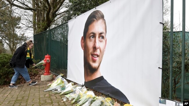 Ramos de flores y otros tributos desplegados cerca de una foto del futbolista argentino Emiliano Sala afuera del predio de entrenamientos del club francés Nantes, el jueves 24 de enero de 2019.