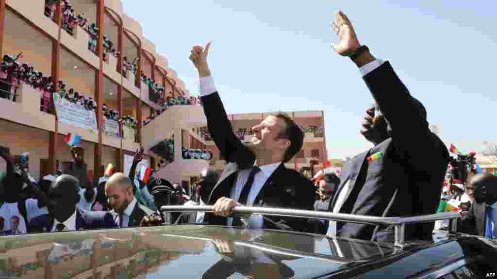 Le président français Emmanuel Macron et le président sénégalais Macky Sall saluent la foule et les étudiants lors de la visite inaugurale de l&#39;école secondaire Bel-Air à Dakar le 2 février 2018.