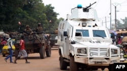 FILE - Police officers from the United Nations Multidimensional Integrated Stabilization Mission in the Central African Republic (MINUSCA) in an armored vehicle patrol a market in Bangui's Combattant district, Sept. 14, 2015.
