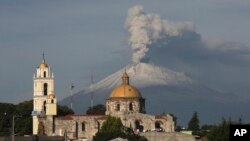 Nhà thờ chính trong thị trấn San Damian Texoloc, Mexico phía sau là núi lửa Popocatepetl phun tro bụi lên không trung ngày 9/7/2013. 