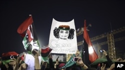 Women with a banner depicting Moammar Gadhafi celebrate the revolution against Gadhafi's regime and demand more women's rights in Tripoli, Libya, Sept. 2, 2011
