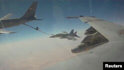 Un avión F/A-18F Super Hornet carga combustible en medio del aire luego de lanzar un ataque contra el Estado Islámico en Irak.