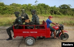 Brazilian army forces soldiers take a ride at the border of Brazil with Colombia during a training which aims to increase the security along borders, in Vila Bittencourt, Amazon State, Brazil, Jan. 18, 2017.