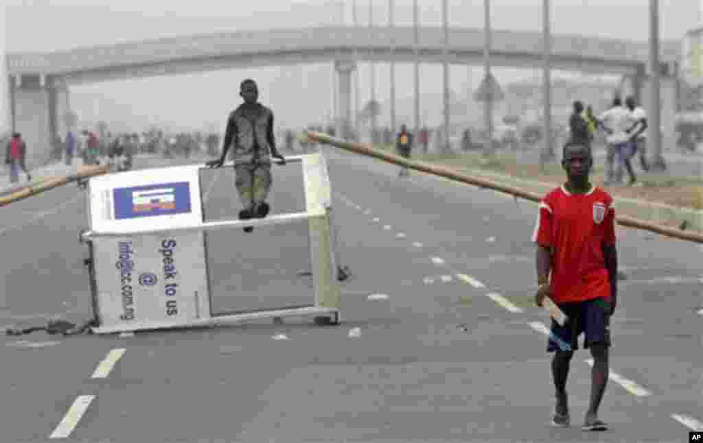 A protesters walk past a barricade at Lekki roads on the third day of nation wide strike following the removal of a fuel subsidy by the government in Lagos, Nigeria, Wednesday, Jan. 11, 2012. Nigeria's government is warning that a paralyzing national stri