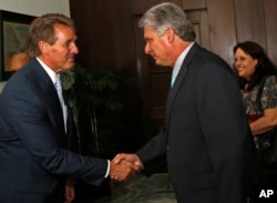FILE - Sen. Jeff Flake, R-Ariz., shakes hands with Cuba's First Vice President Miguel Diaz-Canel at Revolution Palace, in Havana, Cuba, June 13, 2015.