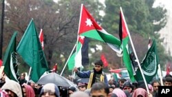 A Jordanian boy holds a national flag during a protest against Jordan's new Prime Minister Marouf Al Bakhit and in support of the Egyptian people in Amman, Jordan, February 4, 2011