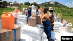 FILE:Villagers collect food aid distributed by the World Food Program (WFP) following a prolonged drought in rural Mudzi district, Zimbabwe, February 20, 2020. Picture taken February 20, 2020. REUTERS/Philimon Bulawayo