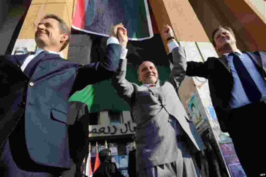 French President Nicholas Sarkozy, left, Libya's NTC leader Mustafa Abdul-Jalil, center, and British Prime Minister David Cameron, right, gesture during their visit to Benghazi, Libya, Thursday, Sept. 15, 2011. Cameron and Sarkozy gave Libya's new rulers