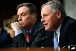 Senate Intelligence Committee chairman Sen. Richard Burr, R-N.C., right, speaks next to Vice Chairman Sen. Mark Warner, D-Va., during a Senate Intelligence Committee hearing on Russian election activity and technology, Nov. 1, 2017, on Capitol Hill.