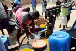 FILE: Residents of Epworth wait to fetch water at a borehole in Harare, Tuesday, Sept, 24, 2019.