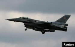 FILE - A Polish Air Force F-16 fighter jet flies near an airbase in Lask near Lodz, central Poland, June 28, 2013.