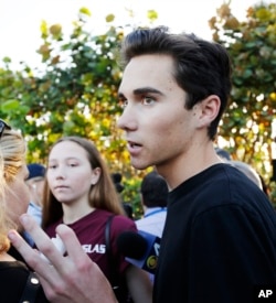 Marjory Stoneman Douglas High School student David Hogg, left, walks to class for the first time since a former student opened fire there with an assault weapon in Parkland, Florida, Feb. 28, 2018.
