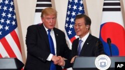 U.S. President Donald Trump, left, and South Korean President Moon Jae-In shake hands during a joint press conference at the presidential Blue House in Seoul, South Korea, Tuesday, Nov. 7, 2017. (Jung Yeon-Je/Pool Photo via AP)