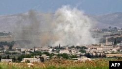 Smoke billows above buildings during reported shelling by government and allied forces, in the town of Hbeit in the southern countryside of rebel-held Idlib province, Syria, May 3, 2019.