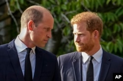 FILE - Britain's Prince William and Prince Harry walk beside each other after viewing the floral tributes for the late Queen Elizabeth II outside Windsor Castle, in Windsor, England, on Sept. 10, 2022.