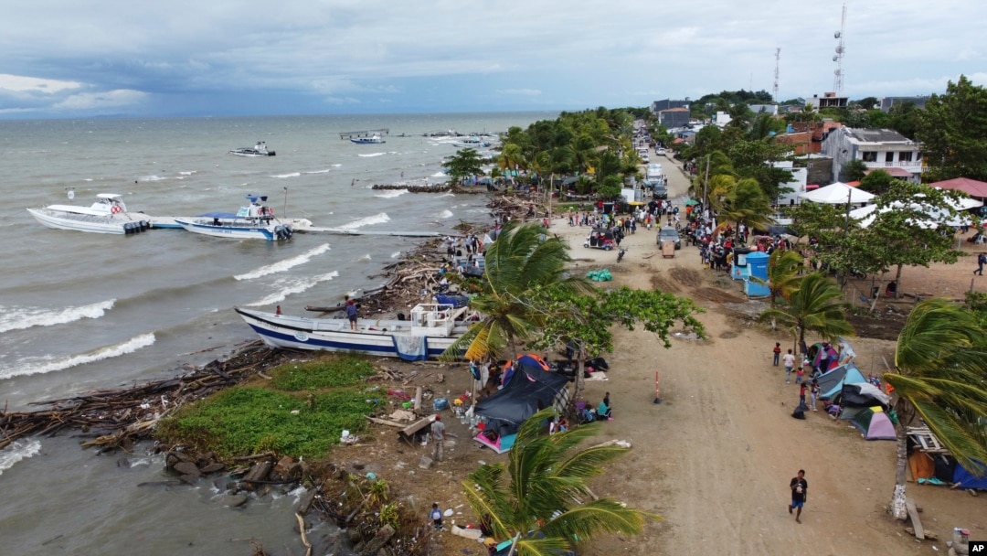 Migrantes se reúnen el 13 de octubre de 2022 en Necoclí, Colombia, un punto de parada para los migrantes que toman embarcaciones hacia Acandí, una localidad que conduce a la selva del Tapón del Darién. 