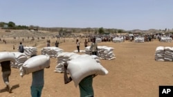 FILE - Sacks of wheat are unloaded at a food distribution site in the town of Adi Mehameday, in the western Tigray region of Ethiopia, Saturday, May 28, 2022.