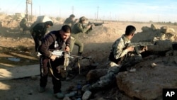 FILE - Iraqi security forces take combat positions on the front line with Islamic State group militants in Ramadi, capital of Iraq's Anbar province, 115 kilometers (70 miles) west of Baghdad, Dec. 10, 2015. 