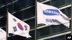 The company flag of Samsung Electronics flutters next to the South Korean national flag in Seoul, South Korea, Jan. 16, 2017.
