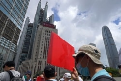 FILE - Pro-China supporters hold a placard on their way to protest at the U.S. Consulate in Hong Kong, May 31, 2020. President Donald Trump has announced a series of measures aimed at China as a rift between the two countries grows.