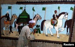 The artist Eid Al Salwaawi paints murals about the holy Kaaba and the rituals of the Hajj pilgrimage to Mecca, in Cairo, Egypt, July 17, 2019.